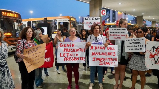 Angélica Torres: “Cerca de cem mulheres e alguns poucos homens percorrem juntos a plataforma superior e o térreo da Rodoviária do Plano Piloto de Brasília com cartazes e flores nas palmas das mãos manchadas de vermelho, aos gritos de "não nos matem!", "mulheres resistem!".